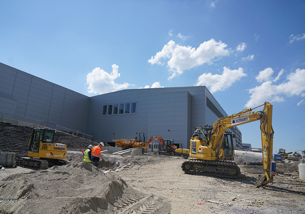 Digger and workmen outside airport