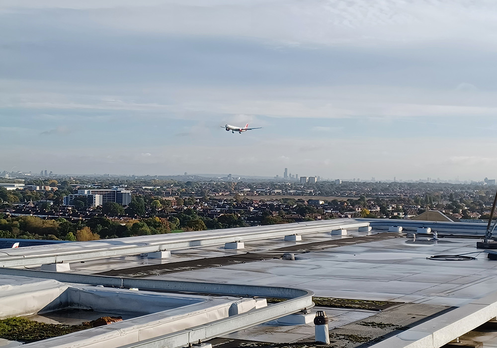Shot on top of roof, plane flying into airport